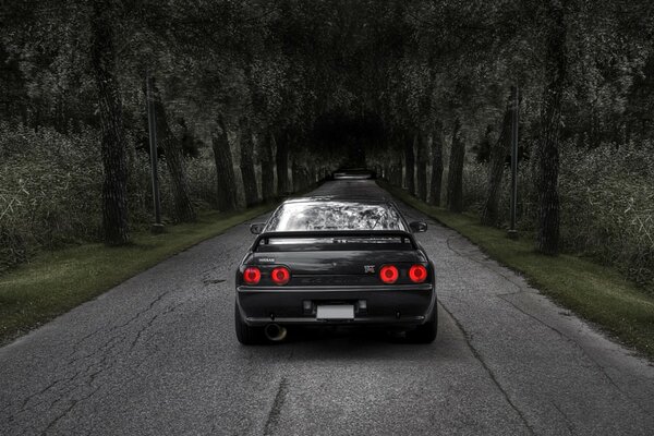 Negro Nissan coche en la carretera en el bosque