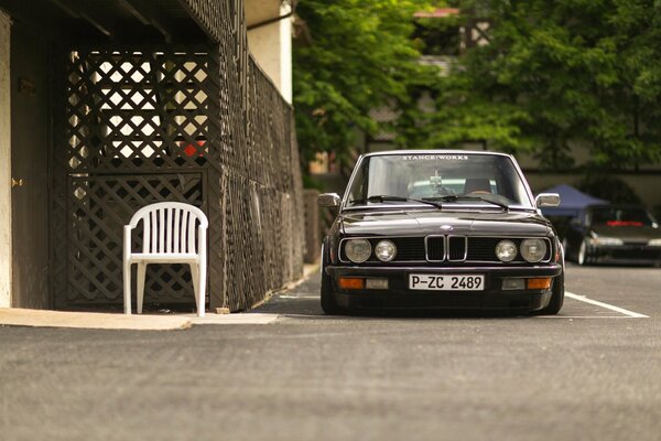 Czarny samochód BMW E28 na tle zieleni