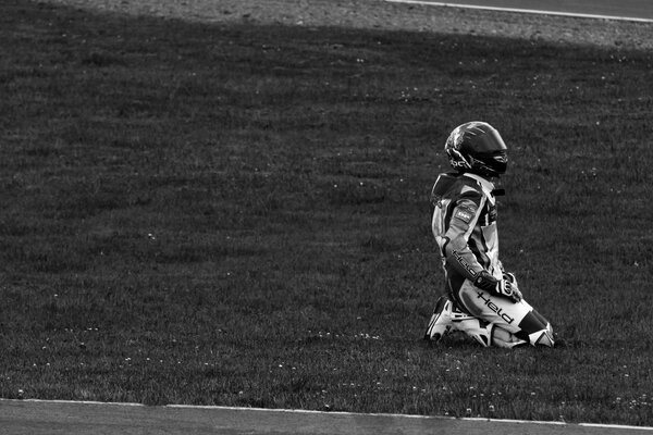 Pilota con casco in ginocchio