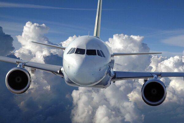 A white plane is flying in the clouds