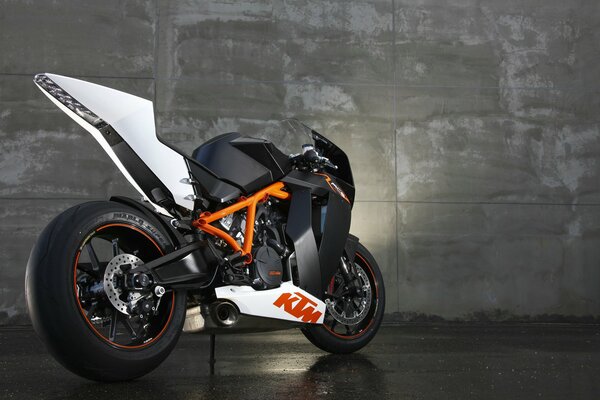 La bici sportiva ktm rc8 si trova sullo sfondo di un muro di cemento