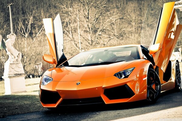 Supercar Lamborghini arancione con porte che salgono verso l alto