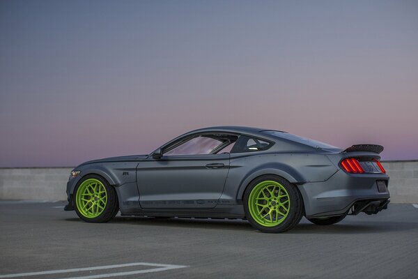 Black Ford Mustang with green wheels