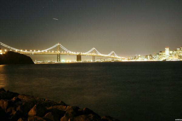 Paisaje nocturno con un puente iluminado