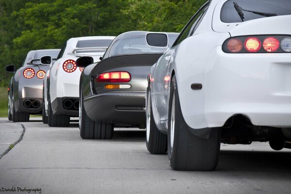 A row of cars are on the road rear view