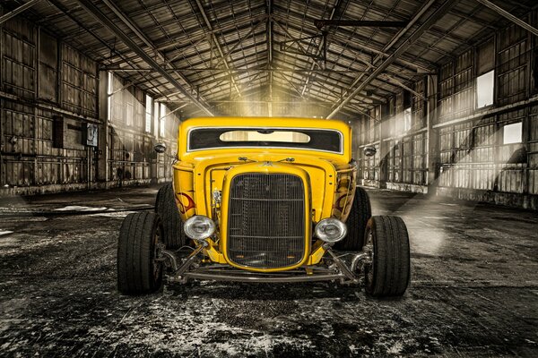 Yellow retro car hot rod in the hangar