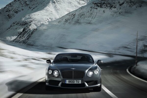 Серебристый bentley континентальный v8 на зимней дороге