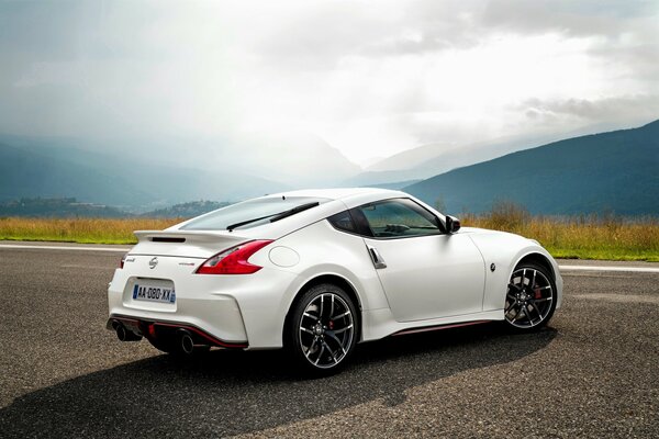 White Nissan on a mountain landscape background