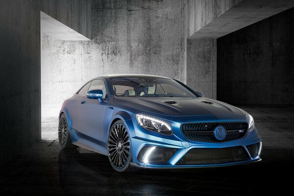 Blue Mercedes on the background of a gray building