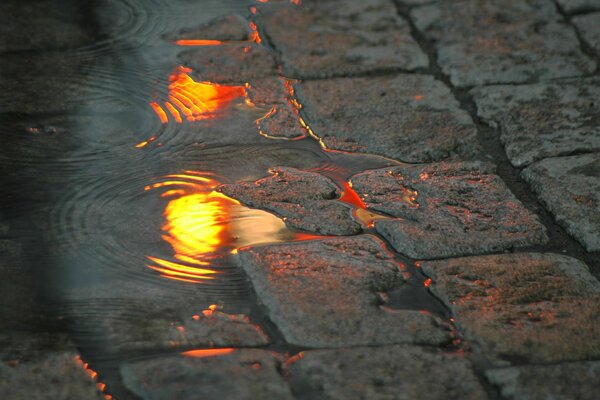 Flaque d eau avec des reflets sur le trottoir de la rue