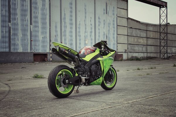 Moto verde sullo sfondo di un edificio abbandonato