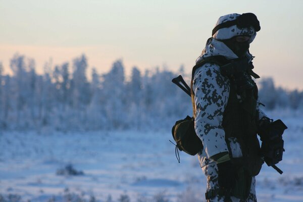 Soldat im Winterfeld mit Waffen