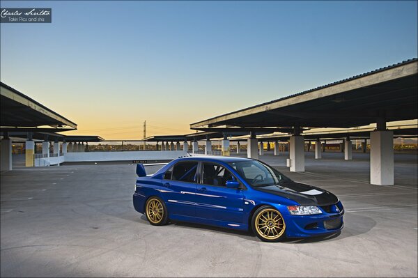 A tuned car in the parking lot at dusk