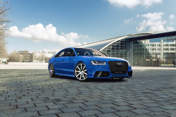 Audi azul con discos blancos en la ciudad