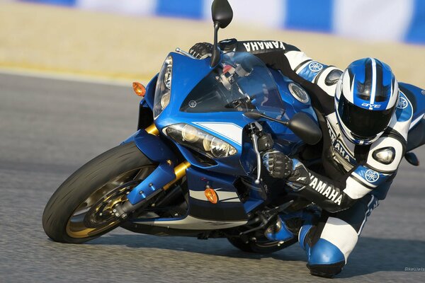 Pilote en costume yamaha sur une moto bleue