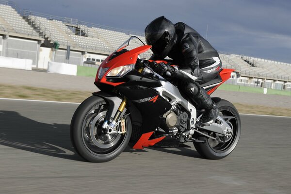 A man rides an aprilia rsv4 motorcycle on a race track