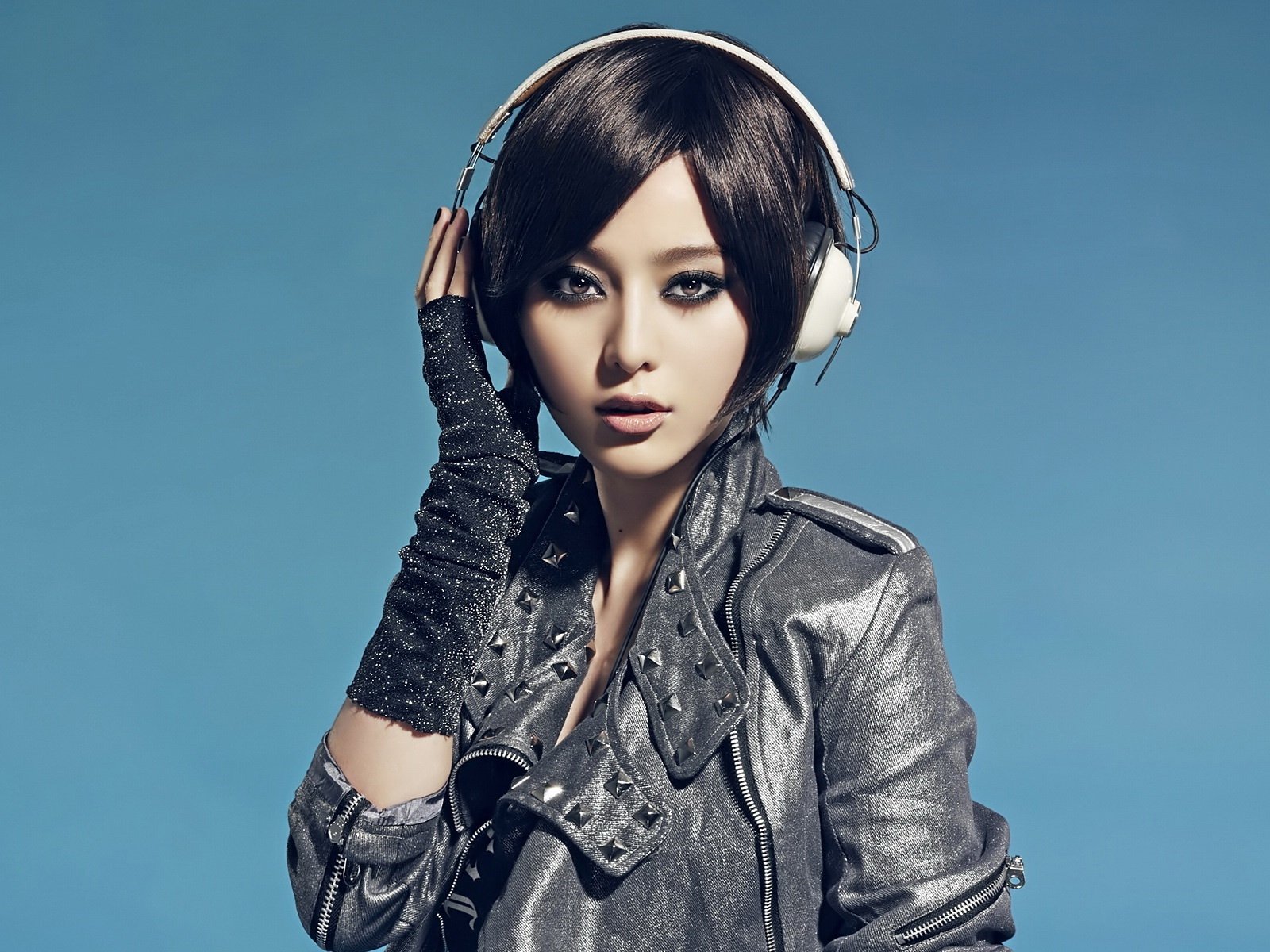 fille asiatique casque veste yeux regard fond musique fond clair fond bleu techno visage brunette cheveux femmes