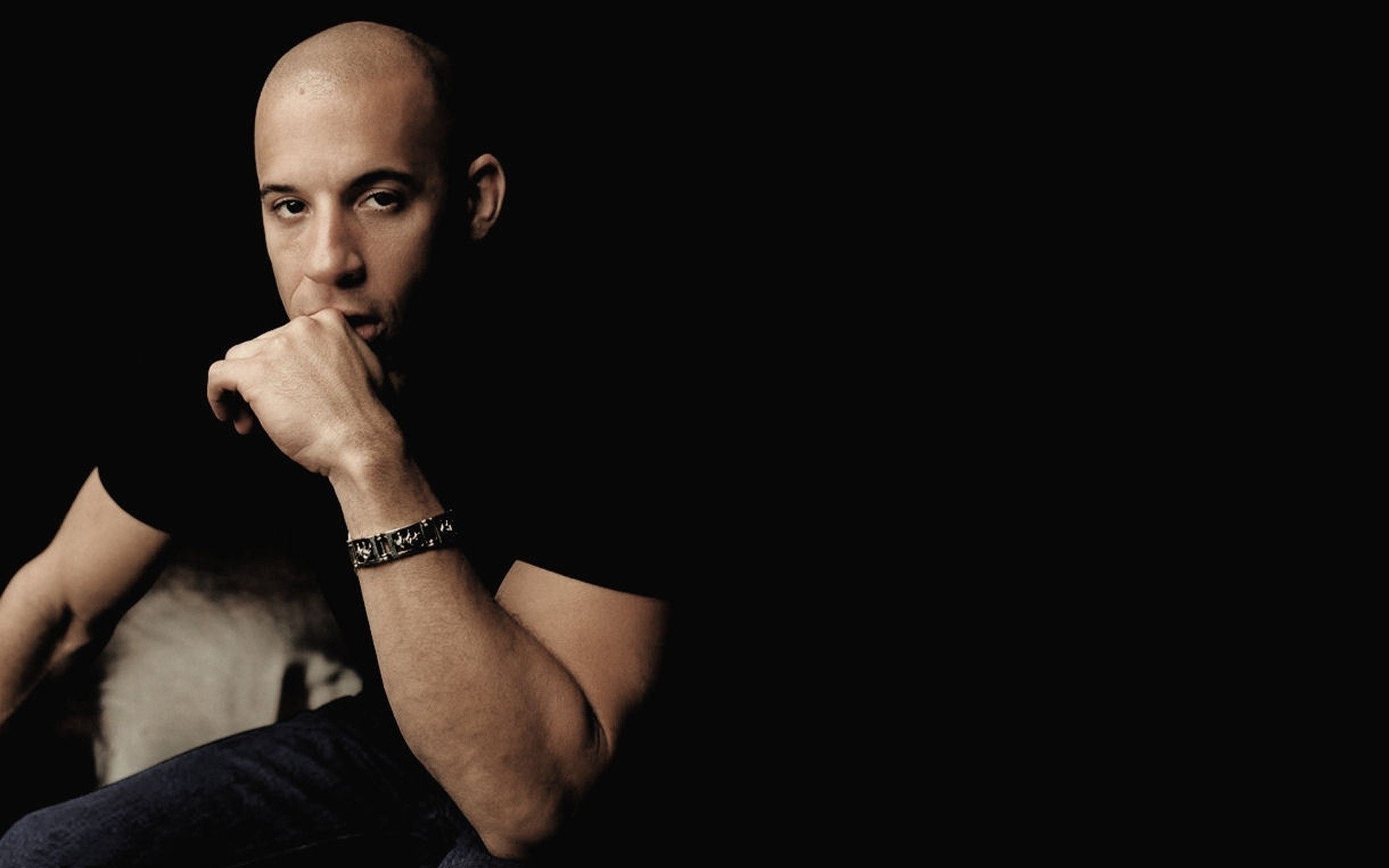 itting dark background vin diesel actor vin diesel man black background bald mulatto guy movies movie actors men eyes face portrait