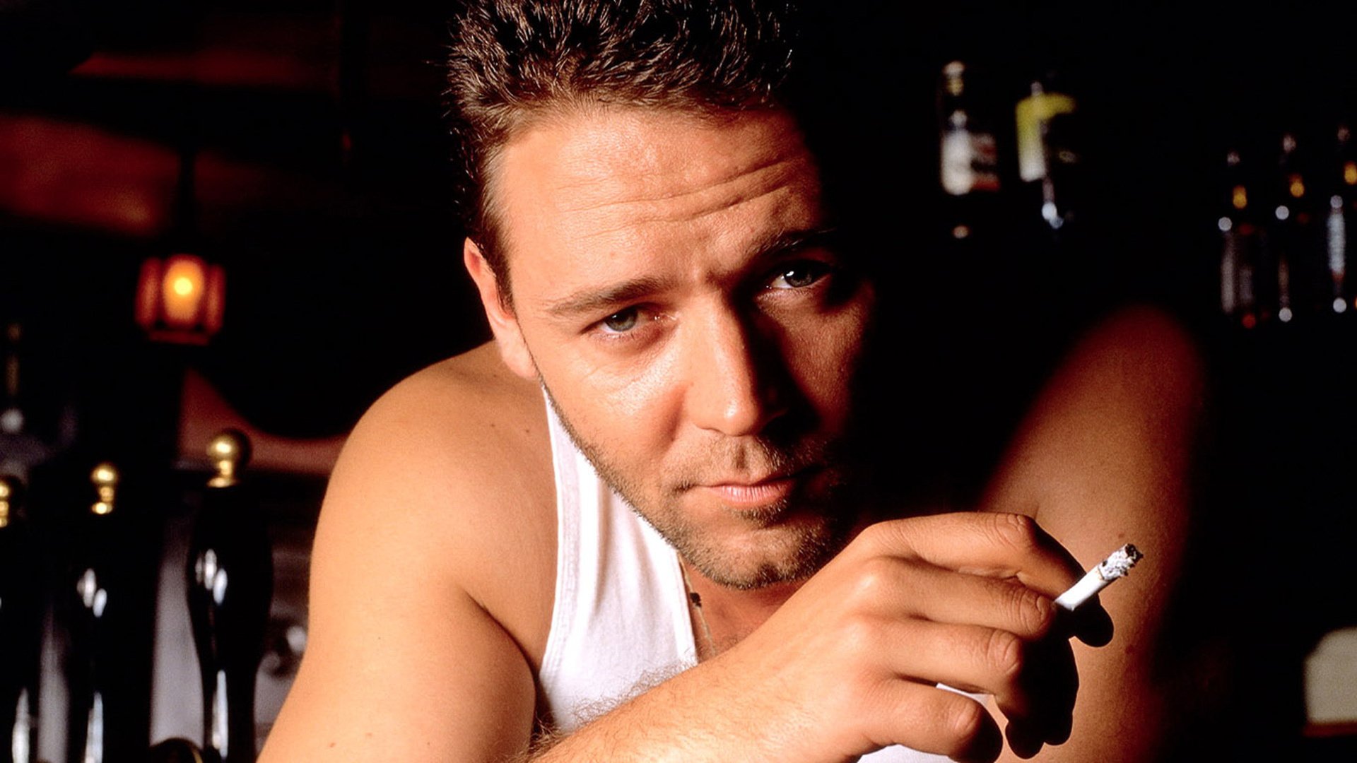 russell crowe actor russell crowe fondo hombre sin afeitar oscuridad cigarrillo fumar camiseta mirada cercana ojos cara retrato