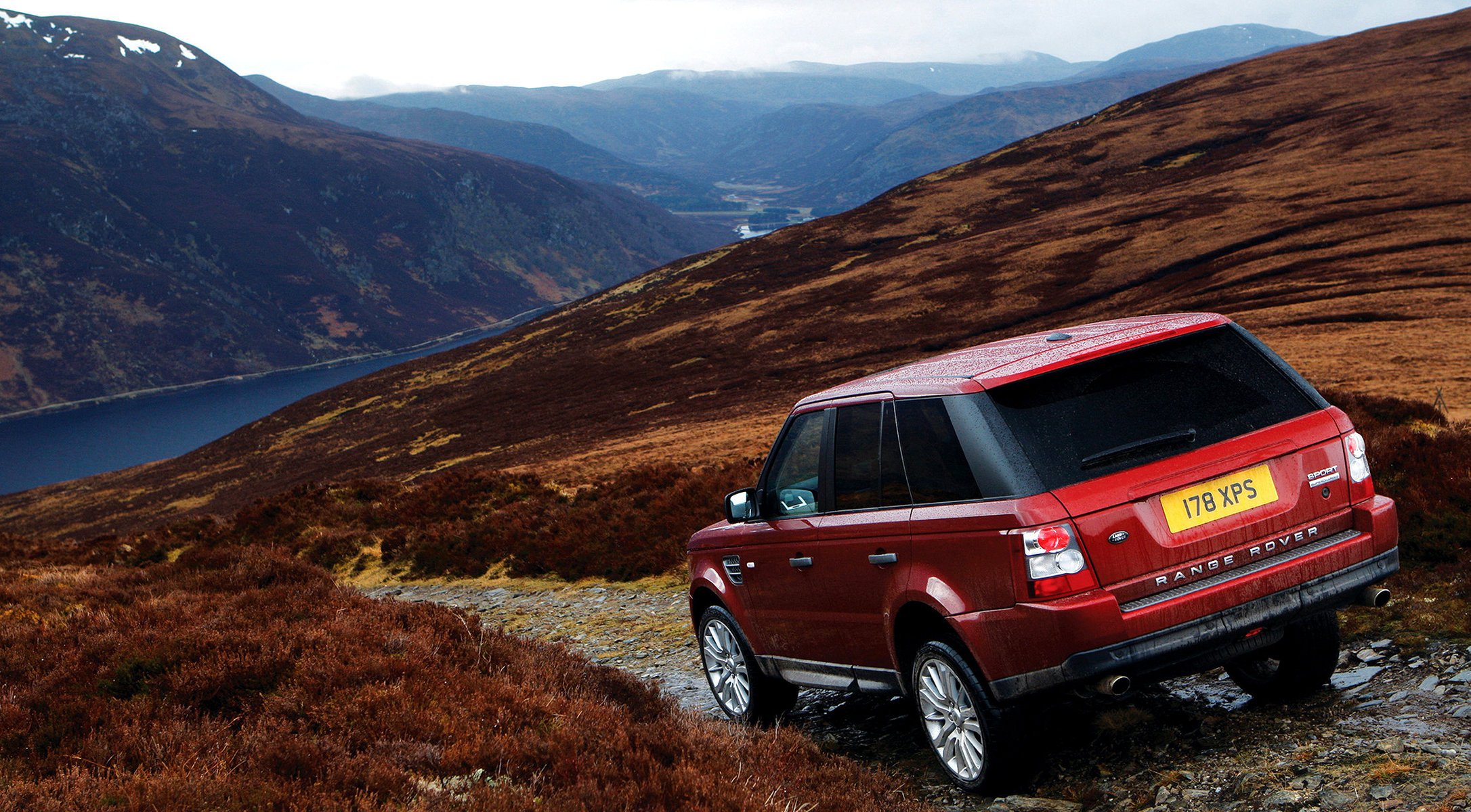 красный горы land rover авто машина красное авто озеро спуск горная местность ландшафт легковые авто автомобили автотранспорт женщины транспорт