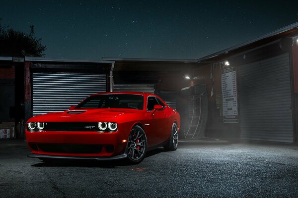 Red car in the evening near garages