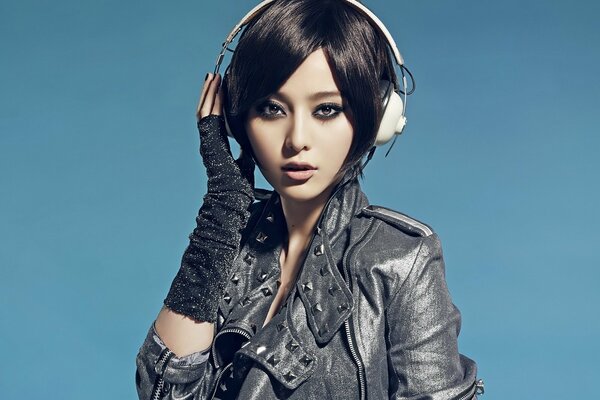 A young Asian woman in a leather jacket and headphones