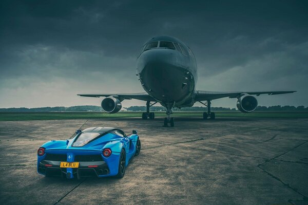 Ferrari sports car on the background of a huge airplane