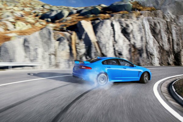 Blue Jaguar XFR-S drifting in the mountains