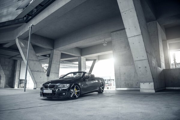 BMW E93 convertible en negro sobre un fondo gris del edificio