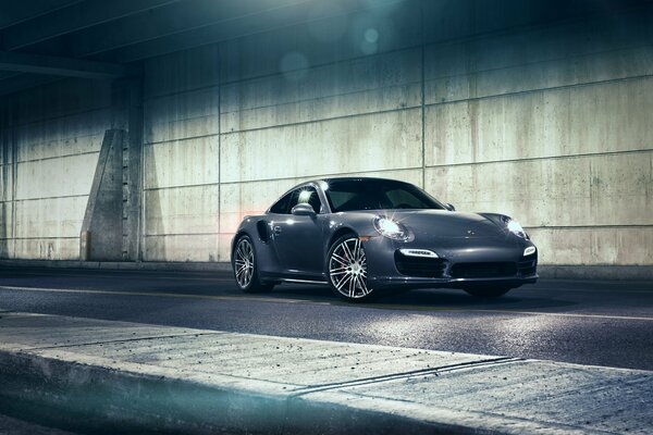 Black porsche carrera 911 turbo on the night road