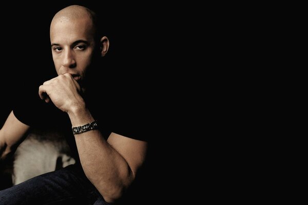 Vin Diesel mit einem Armband am Arm im Dunkeln
