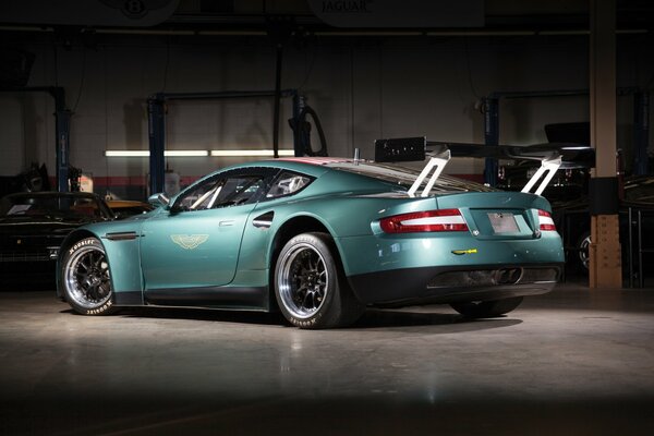 The Aston Martin is in the garage. Rear view