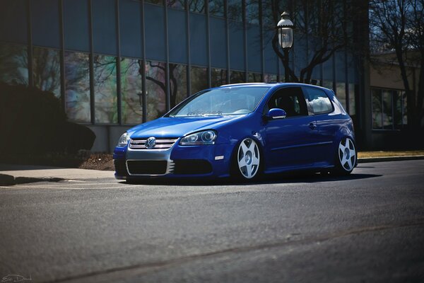 Blue Volkswagen on grey asphalt