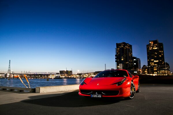Sportowy czerwony hipercar Ferrari na nabrzeżu