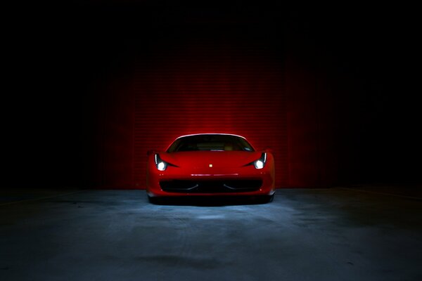 Ferrari rouge chic avec phares allumés sur fond de mur de béton