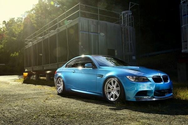 BMW m3e92 bleu Atlantique sur fond de forêt clôturée ensoleillée