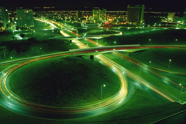 Girando el camino nocturno en medio de luces verdes