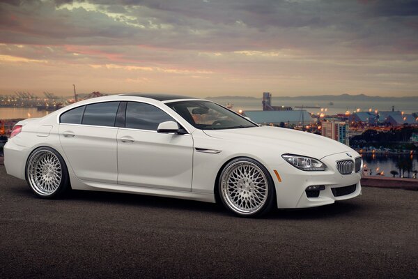 White tuned BMW 650i car on the background of the city