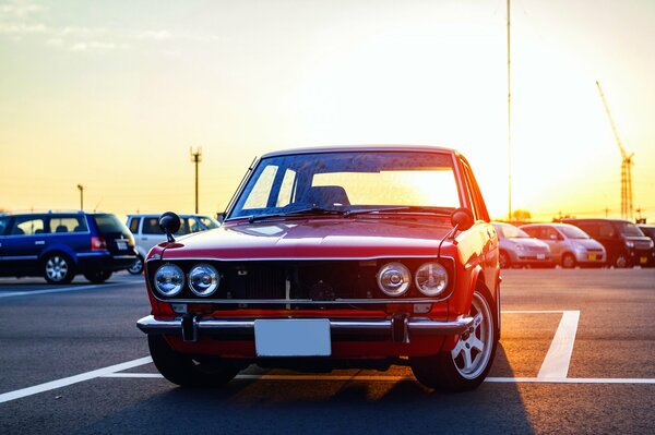 Red datsun in the rays of the setting sun