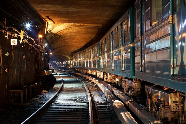 Z tunelu oświetlonego światłem przyjeżdża pociąg