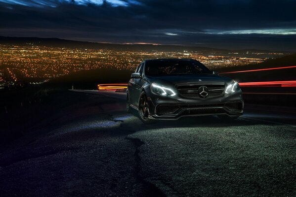 Mercedes negro en el fondo de la ciudad de la noche