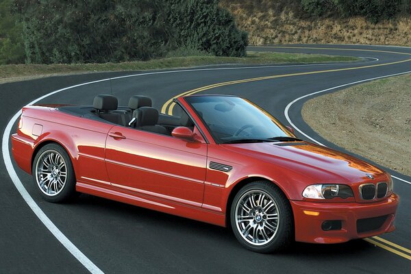 BMW E46 convertibile rossa su una strada tortuosa