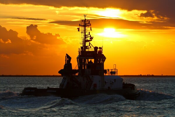 A ship on the background of a stunning sunset at sea