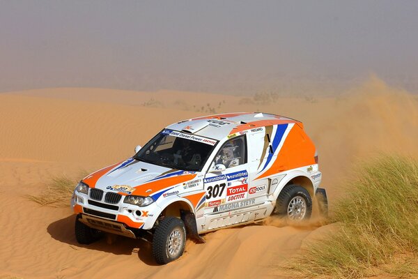 Il SUV bmw x3 al rally Dakar guida su un Barchan di sabbia