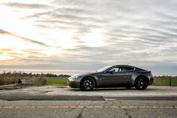 Aston Martin im Hintergrund der ländlichen Landschaft. Sonnenuntergang. Panzer