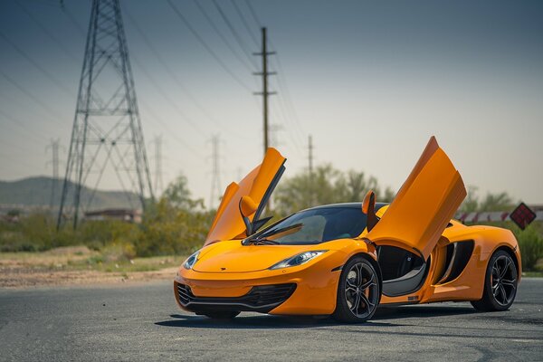 McLaren naranja en el fondo de los soportes de alto voltaje