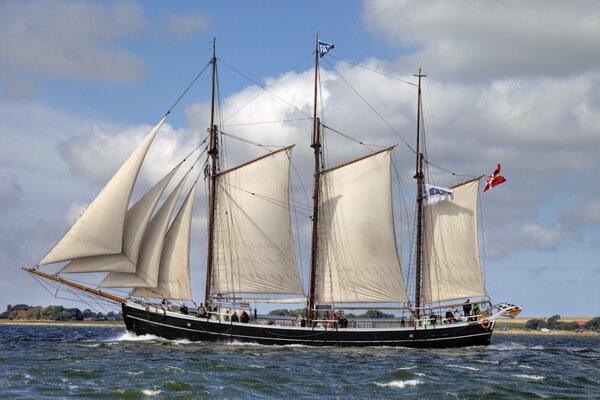 Navire avec des voiles levées au milieu des vagues