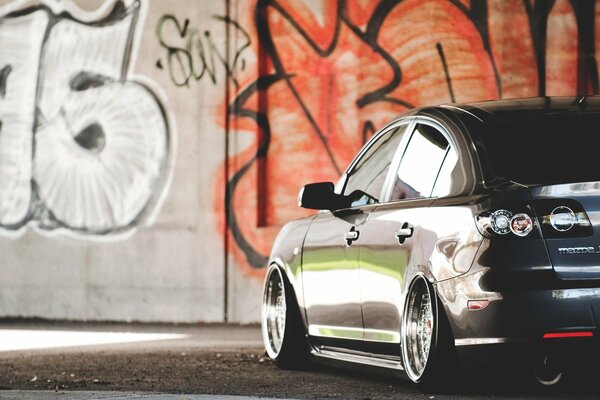 Mazda car on the background of a wall with graffiti