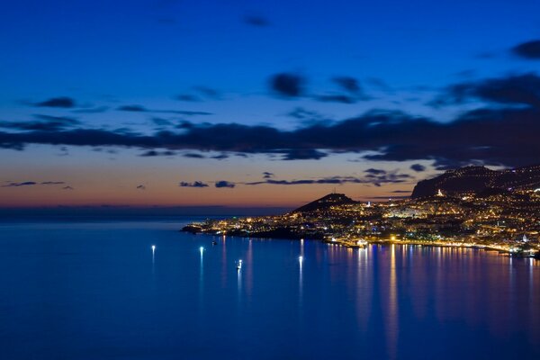 Puesta de sol en la bahía con luces reflectantes