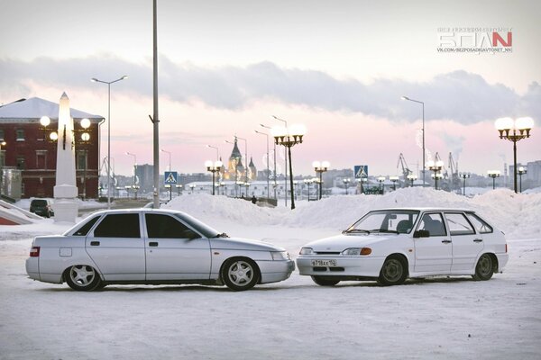 Priora and VAZ 2114 against the background of a winter city